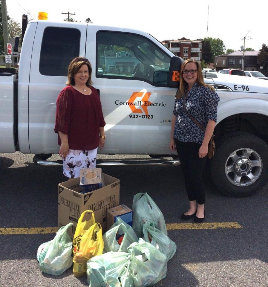 Two women in front of Cornwall Electric truck with food donations