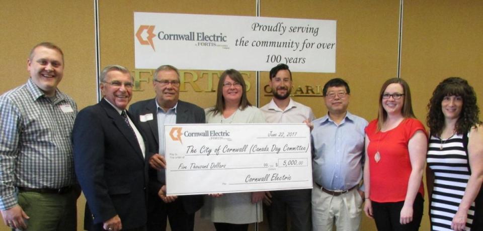 People holding large $5,000 donation cheque for the Kid Zone Canada Day Committee